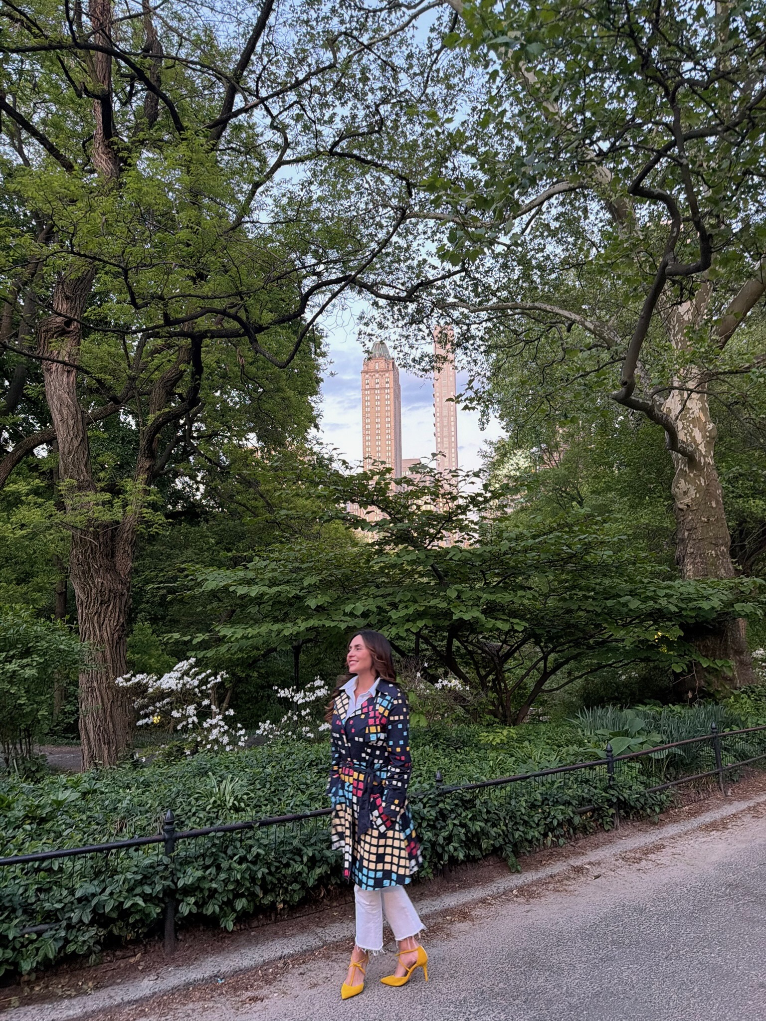 A woman walking thoughtfully through a peaceful park surrounded by trees, reflecting during a quiet moment of emotional and spiritual processing.